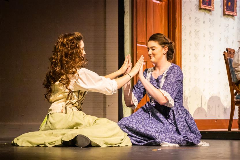 Two actors play pattycake onstage